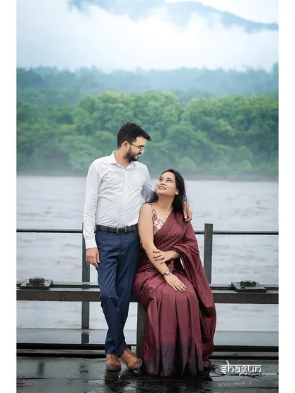 A sweet moment on a jetty overlooking the water. The lush green hills and cloudy sky create a soft, beautiful backdrop for this romantic couple portrait.