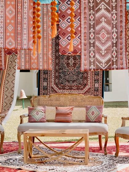 A boho-chic lounge setup for a Moroccan-themed Haldi in Goa. The seating features elegant traditional furniture set against a backdrop of layered, patterned textiles.