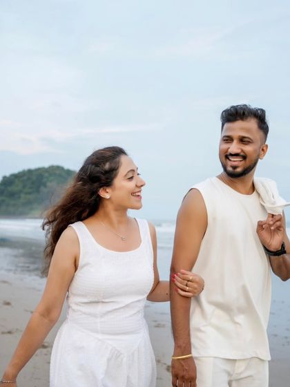 A candid moment of conversation and smiles while walking on the beach, showcasing the couple's easy chemistry.