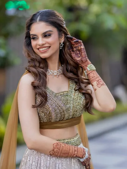 Adjusting her hair, this bride looks radiant and relaxed. The combination of soft curls and glowing makeup created a perfect look for her outdoor engagement photos.