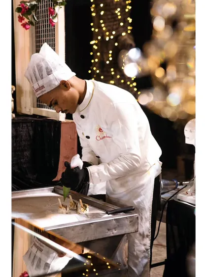 A chef meticulously preparing bite-sized appetizers at a live station. The focus and precision ensure that every single piece is perfect.