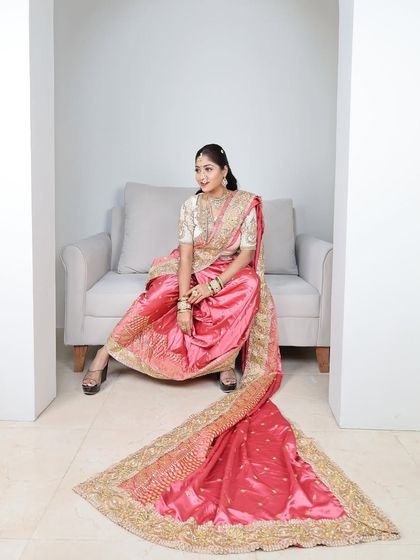 A stunning pink brocade Nauvari with a long, flowing trail and heavy gold border, perfect for a pre-wedding photoshoot.