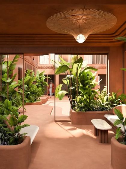 The waiting area outside the restaurant is filled with lush plants and features built-in seating, creating a calm and natural transition space.