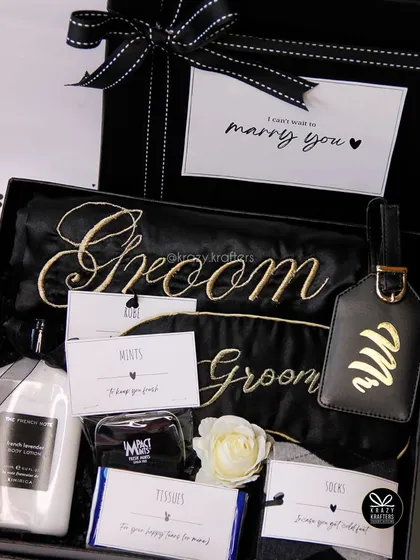 I also create hampers for the groom. This 'Groom Survival Kit' is a fun and stylish way to pamper him before the big day, complete with a personalized robe, luggage tag, and other thoughtful goodies.