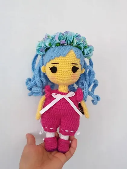 A slightly different angle of the blue-haired anime-style doll, showing the floral hair accessory and detailed outfit.