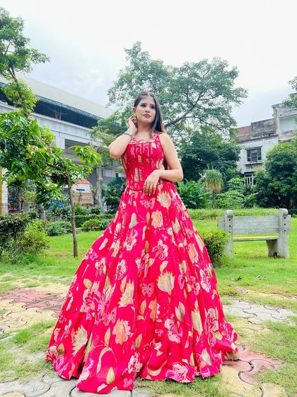 A full-length shot of the pink floral gown in an outdoor setting. It's a perfect pre-wedding or party outfit.