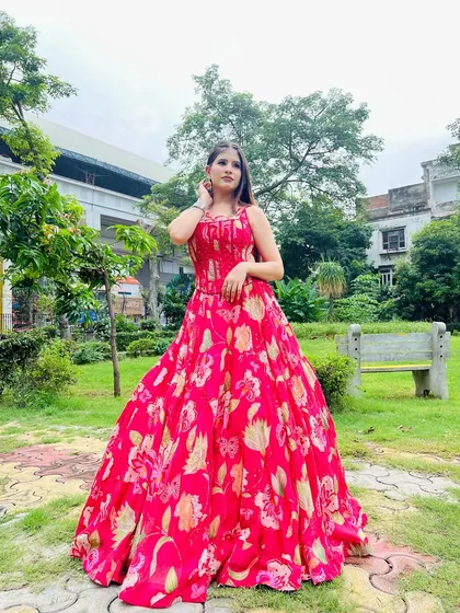 A full-length shot of the pink floral gown in an outdoor setting. It's a perfect pre-wedding or party outfit.