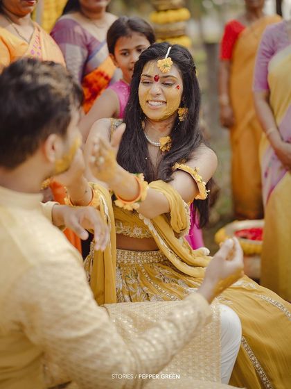 A joyful moment from Medhus and Adi's Haldi ceremony. The smiles and playful interactions between the couple and their family are the heart of the celebration.