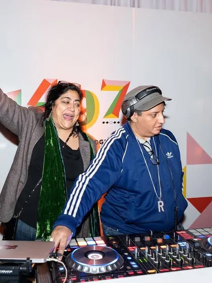 Sharing a laugh with a friend behind the decks at a gala. Even at formal events, the vibe is always about joy and connection.