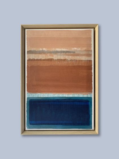 This stunning abstract piece is presented in a custom floater frame. The light wood tone of the frame complements the earthy browns and vibrant blues of the artwork.