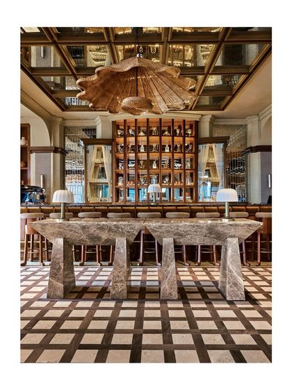This stunning shot from the AD feature shows the monumental stone tables set against the intricate wood and stone checkerboard floor. It's a testament to how bold surfaces can define a luxury space.