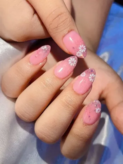 A beautiful rose gold ombré set. The design features a pink base that fades into a sparkling rose gold glitter tip, with delicate white daisies painted on top.