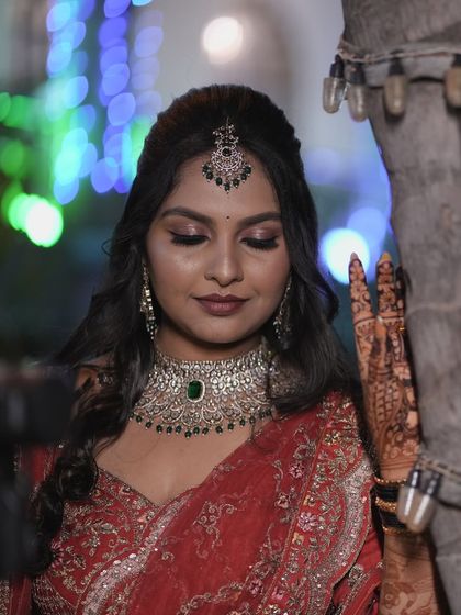 A beautiful, artistic shot of Amrutha on her reception night. The soft focus and bokeh lights highlight her glowing makeup, which features a subtle smokey eye and elegant diamond jewelry.