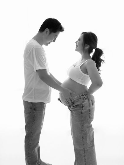 The first chapter of a lifelong story. This black and white photo captures the pure, unfiltered joy and laughter between a couple expecting their child.