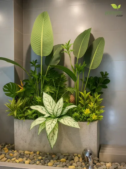 This concrete planter with a mix of tropical plants adds a modern touch to a bathroom or entryway. The bed of pebbles at the base provides a clean, finished look.