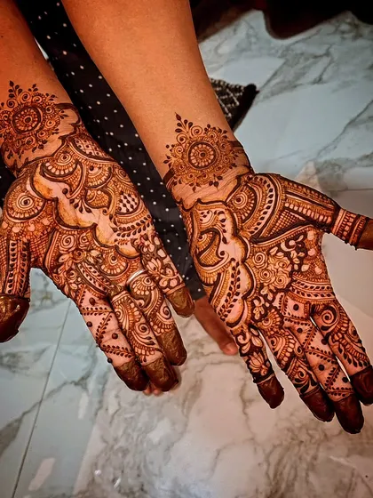 This design combines a central mandala on one hand with a more flowing, asymmetrical pattern on the other. It's a fun way to mix and match styles.
