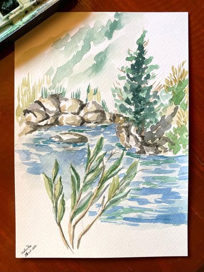 A serene watercolor painting of the Tirthan river, with rocks and a pine tree by the water's edge. I painted this on location, trying to capture the soothing movement of the river and the peace of the valley.