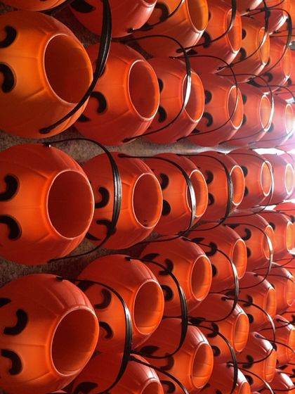 The raw materials for our Halloween bulk order. Rows of pumpkin-shaped buckets waiting to be filled with treats and packed into our custom-designed spooky boxes.