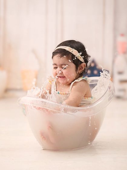 A candid action shot of a happy splash. Our milk bath photography sessions are full of these playful, unscripted moments.