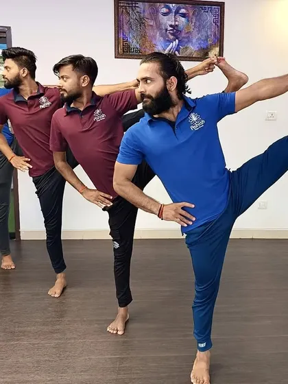 A group of instructors demonstrates a synchronized standing balance pose, showcasing the high level of practice and discipline at our school.
