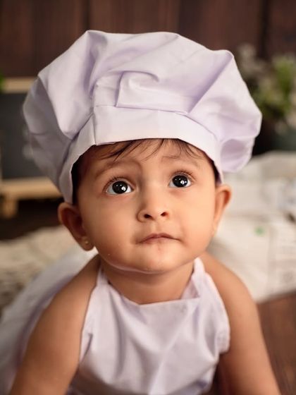 A close-up of our adorable little chef. Her curious eyes and sweet expression are the main ingredients in this heartwarming baby chef themed photoshoot.