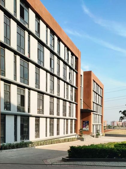 The façade of Sage University, showcasing the rhythmic pattern of windows and the use of terracotta. The building's form and materials were chosen to be both modern and responsive to the local climate.