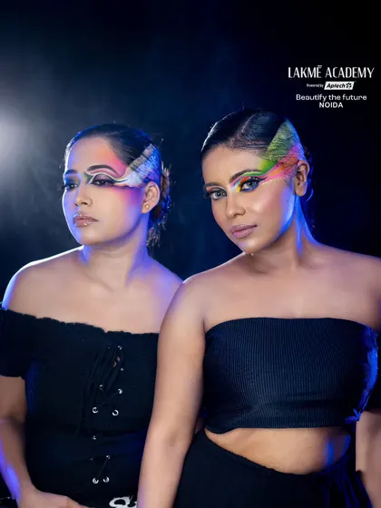A dramatic shot of two models with creative eye makeup. The use of smoke and dark lighting adds a moody and high-fashion feel to the image.