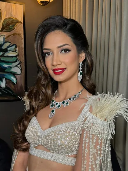The client's red lip and glamorous waves create a classic, show-stopping combination.
