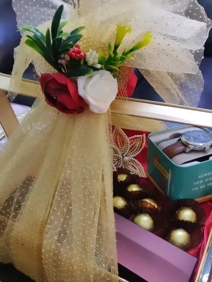 I also create custom trousseau boxes for the groom. This gift box includes a new watch, a selection of Ferrero Rocher chocolates, and is finished with a stunning gold net and floral arrangement.