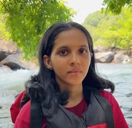 A camper shares her feedback against the backdrop of the flowing river in Dandeli.