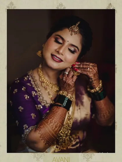 A bride getting ready, wearing her custom purple embroidered blouse. The image captures the rich color and intricate detail of the handwork.
