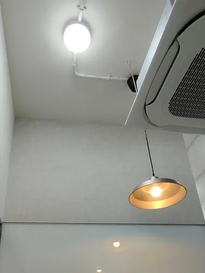 This view shows how I expertly install wallpaper around and above fixtures like a large AC unit, ensuring a clean and professional finish even in tricky spots.