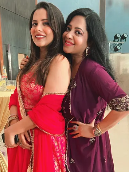 A happy moment with a friend at the wedding. My red suit was bright, festive, and perfect for the occasion.
