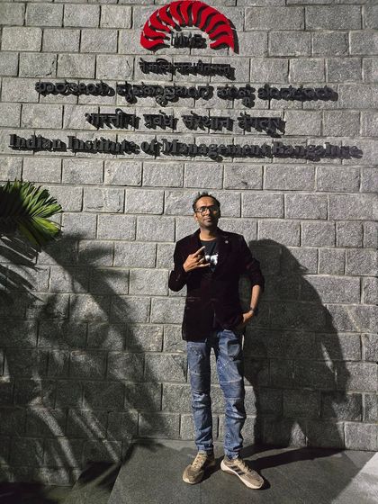 Posing in front of the iconic Indian Institute of Management, Bangalore wall after a successful performance.