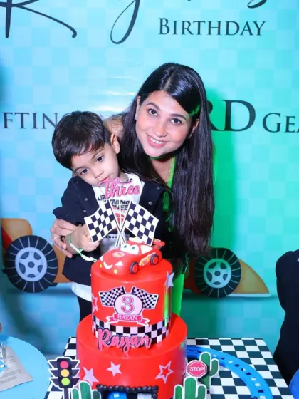 A mother and her son celebrate his third birthday with an amazing 'Cars' themed cake.
