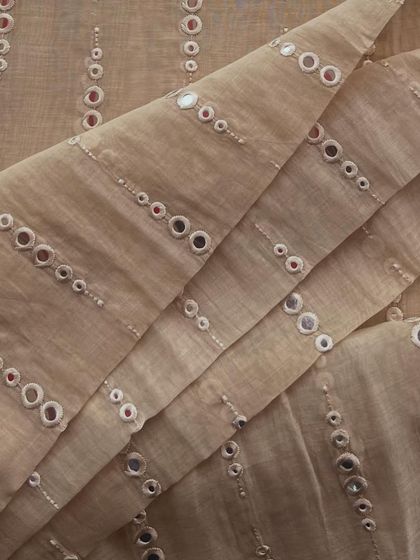 Our mirror-work Mul Chanderi in a classic beige. The reflective charm of the mirrors makes this a perfect fabric for festive celebrations.