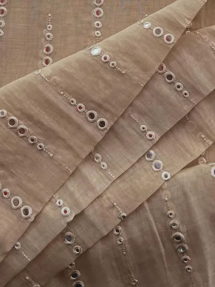Our mirror-work Mul Chanderi in a classic beige. The reflective charm of the mirrors makes this a perfect fabric for festive celebrations.