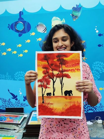 A joyful and vibrant painting of an elephant family. The artist's smile says it all.