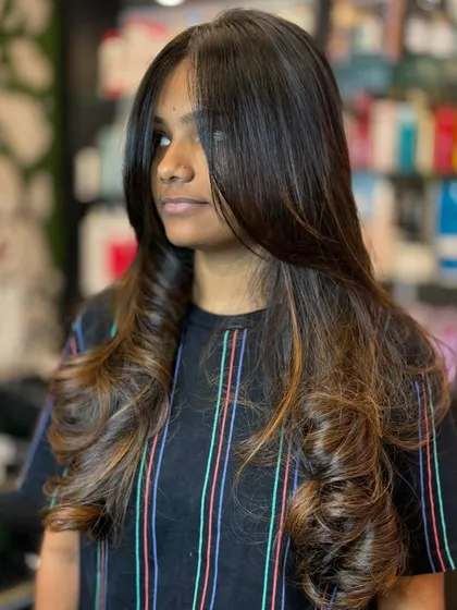 A perfect haircut is tailored to your hair type and style. Here, we've added soft curls to a layered cut with subtle highlights to create a look that is full of volume and dimension.