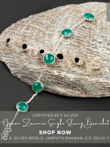 A delicate bracelet featuring green zirconia stones set on a single string chain. This minimalist piece is perfect for a subtle touch of color.