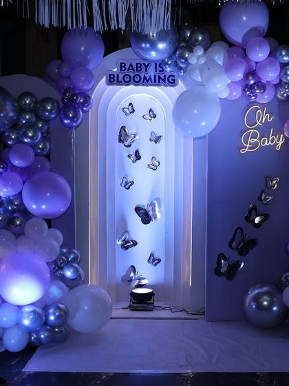 A closer look at the butterfly-themed backdrop. The silver butterflies appear to flutter up through the archway, creating a sense of movement and whimsy.