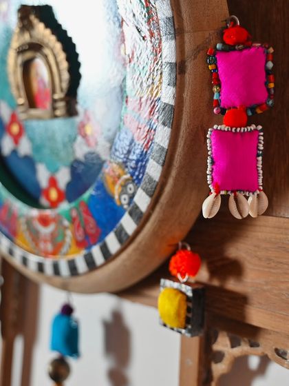 This image highlights the beaded and shell-adorned fabric charms that I create from studio scraps to embellish the Devi frames. These small details are an essential part of my zero-waste process and add a unique textural element.