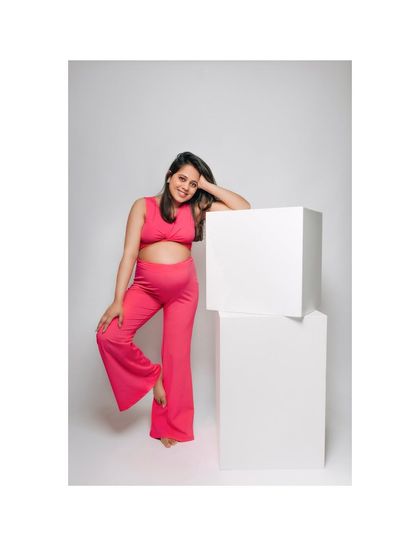 A full-body shot showcasing the modern, bright pink maternity outfit. This image is perfect for moms who want a contemporary and colorful studio session.