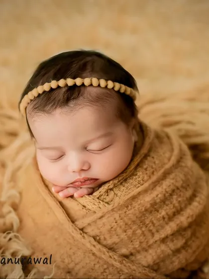 Wrapped in soft, earthy tones, this portrait highlights the serene beauty of a sleeping newborn. My focus is always on your baby's comfort, using safe wrapping techniques and simple, elegant props to create a peaceful and natural look.