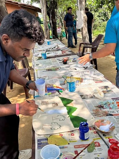 A volunteer from Valvoline Cummins paints a nature-inspired design on an eco-friendly canvas bag during a creative workshop at our Aranya nursery.