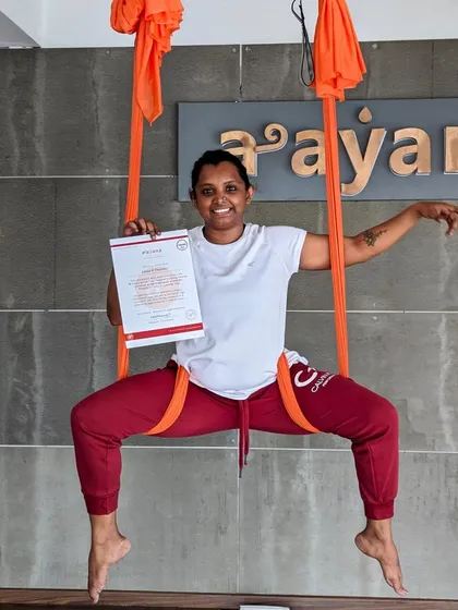 A graduate strikes a powerful pose in the hammock, celebrating her new certification.
