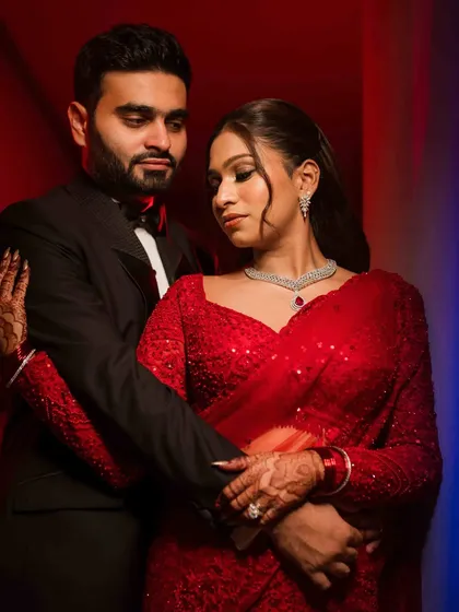 A moody and romantic portrait of the couple. The mix of red and blue lighting adds a modern, artistic touch to this intimate moment.