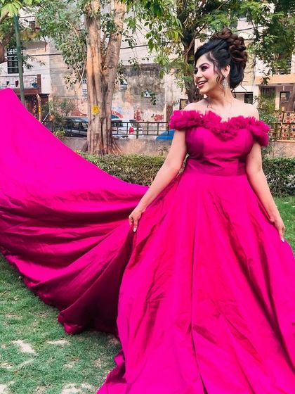 Three angles of our vibrant magenta off-shoulder gown with a long trail. These photos showcase its stunning color and dramatic flair, perfect for outdoor pre-wedding shoots.
