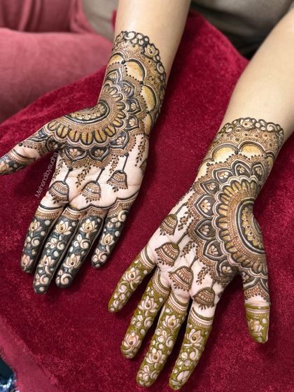 A clear view of the full design, showcasing the semi-circle mandala on the back of the hands and the delicate bell-like jhumkas on the palms. The use of negative space makes the design pop.