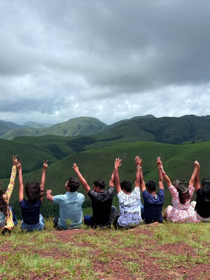 Another angle of our group celebrating at the viewpoint, with their hands up, overlooking the beautiful Western Ghats.